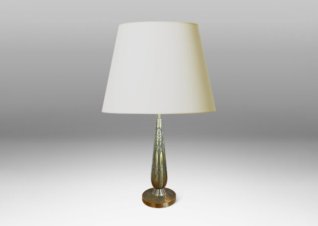 Gallery BAC elongated drop form on a disk plinth, ornamented with carved foliate pattern; patinated brass