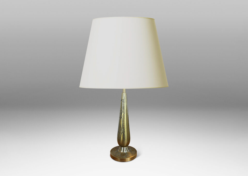 Gallery BAC elongated drop form on a disk plinth, ornamented with carved foliate pattern; patinated brass