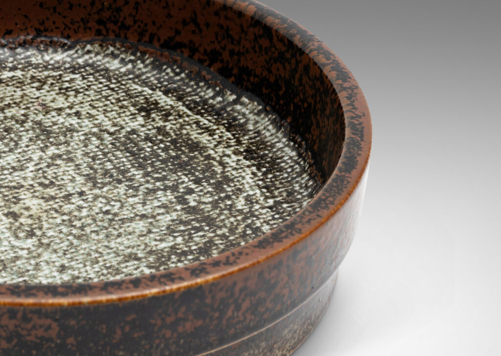 Gallery BAC drum-form with stepped straight sides and a flat bottom with textile-like pattern, glazed in black-red luster on the sides and green-gray-pale gray on the bottom