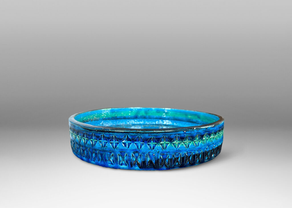 Gallery BAC low straight side and rows of impressed geometric forms, glazed in bright cerulean tones with bands in green-tint and indigo