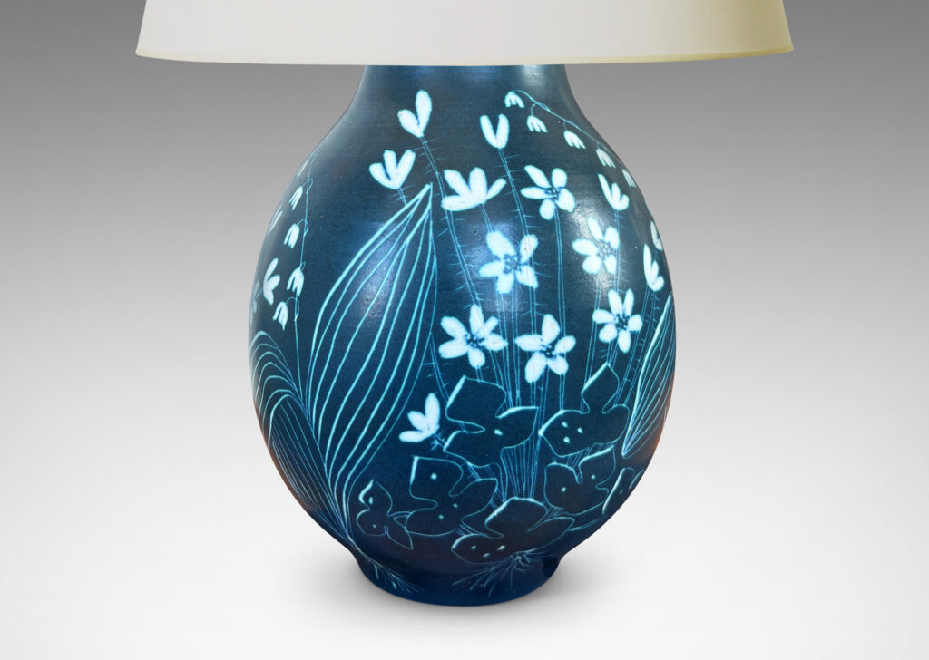 Gallery BAC ovoid form glazed in a deep cerulean tone, with a carved sgraffito wildflower design