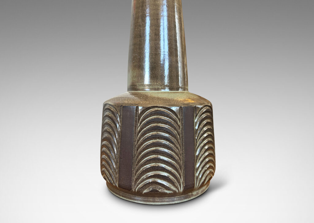 Gallery BAC drum form with carved panels of arc motifs and tall conical stand, glazed in an eggshell finish brown-taupe, with matte brown accents