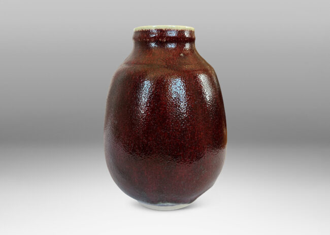 Gallery BAC ovoid form with large articulated mouth, glazed in a deep burgundy oxblood with pale gray accents