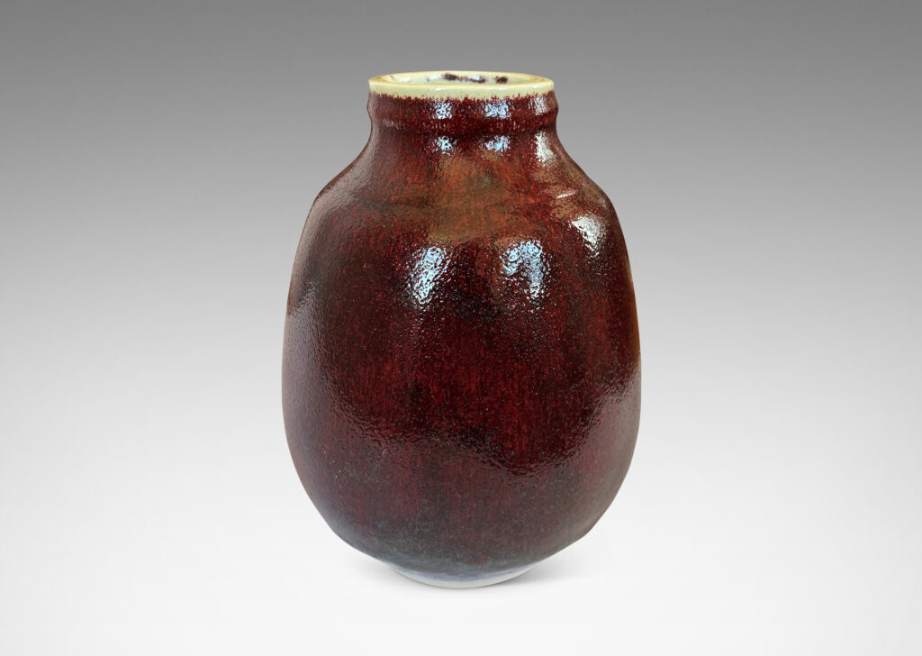 Gallery BAC ovoid form with large articulated mouth, glazed in a deep burgundy oxblood with pale gray accents
