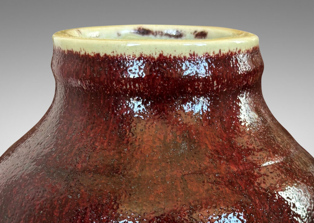 Gallery BAC ovoid form with large articulated mouth, glazed in a deep burgundy oxblood with pale gray accents