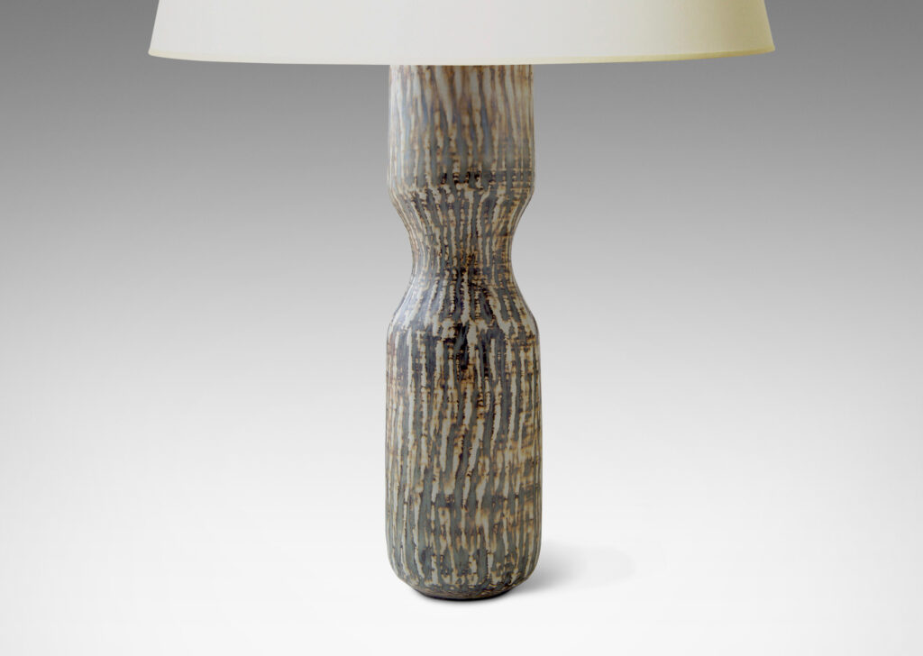 Gallery BAC slender hourglass form with a waist-like cinch and carved texture of diagonal hatches in stoneware with a flowing brown “Birka” glaze