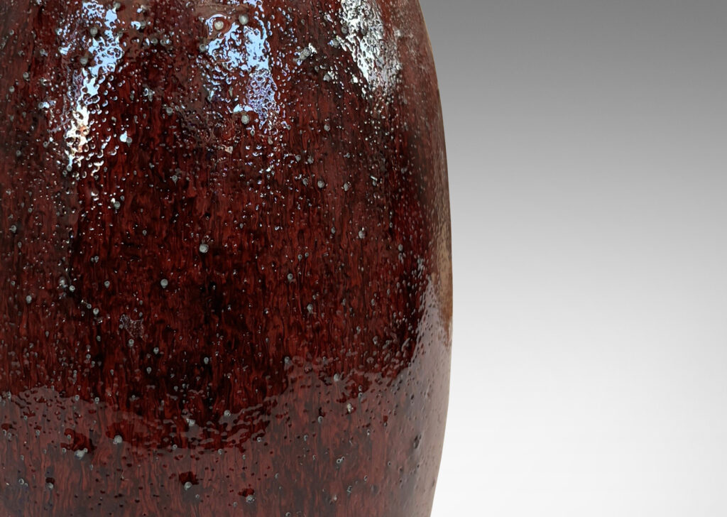 Gallery BAC ovoid form with wide outstretched mouth and ridged shoulder, glazed in a deep burgundy oxblood with pale gray accents