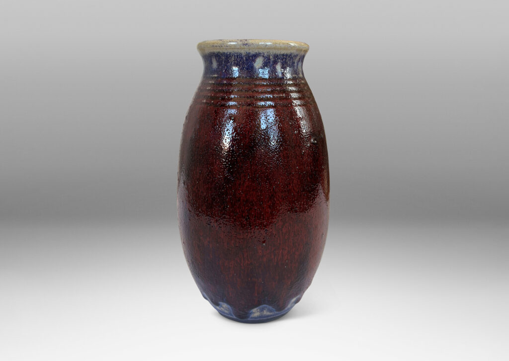 Gallery BAC ovoid form with wide outstretched mouth and ridged shoulder, glazed in a deep burgundy oxblood with pale gray accents