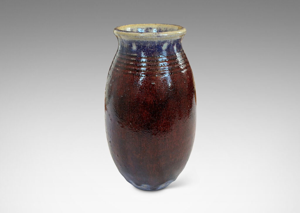 Gallery BAC ovoid form with wide outstretched mouth and ridged shoulder, glazed in a deep burgundy oxblood with pale gray accents
