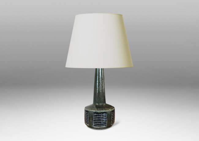 Gallery BAC low drum form with carved score patterning and tall neck, glazed in a shiny gray-green, with blue accents