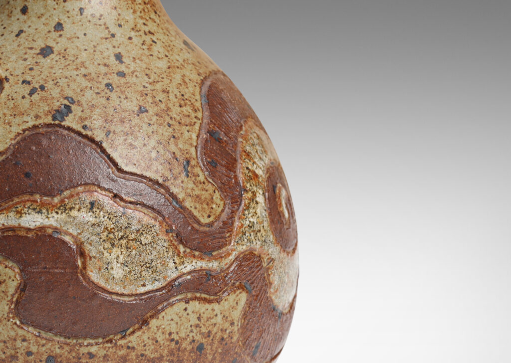 Gallery BAC plump globe form with tall attenuated neck, encircled in a textured relief of organic form, glazed in brown and gauzy white against brown spotted pale gray