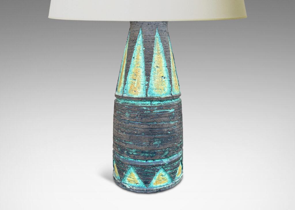 Gallery BAC cylindrical form with its top half upwardly tapered, with carved triangular motifs, glazed in matte brown with green and mustard yellow