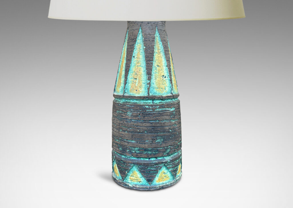 Gallery BAC cylindrical form with its top half upwardly tapered, with carved triangular motifs, glazed in matte brown with green and mustard yellow