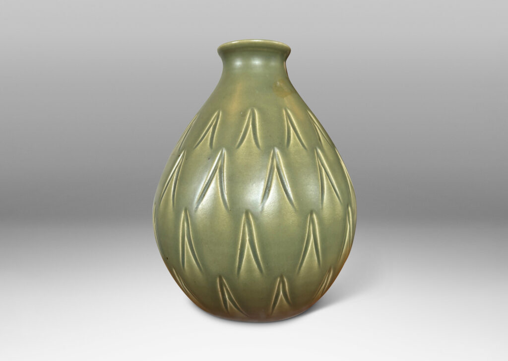 Gallery BAC swelling form with small mouth and carved carat motifs, glazed in a warm green with black interior