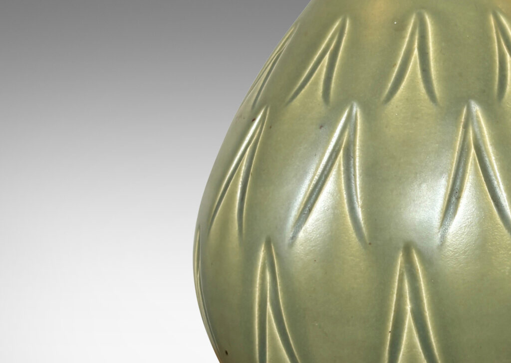 Gallery BAC swelling form with small mouth and carved carat motifs, glazed in a warm green with black interior