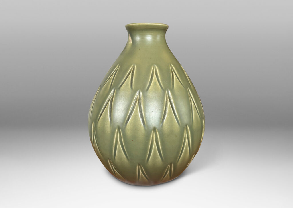 Gallery BAC swelling form with small mouth and carved carat motifs, glazed in a warm green with black interior