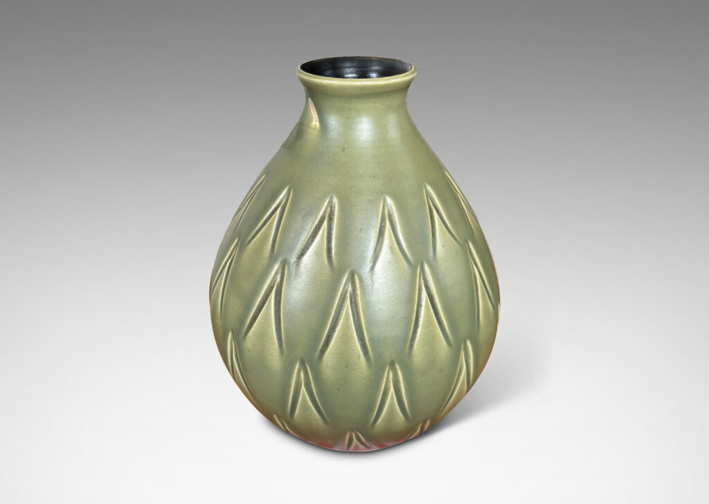 Gallery BAC swelling form with small mouth and carved carat motifs, glazed in a warm green with black interior