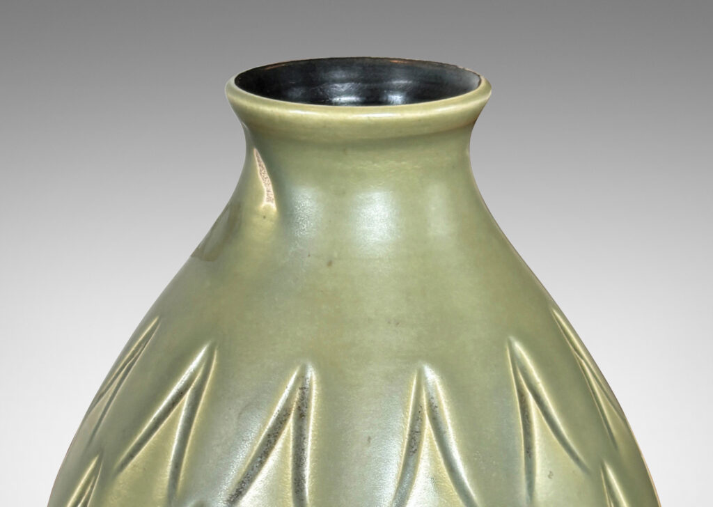 Gallery BAC swelling form with small mouth and carved carat motifs, glazed in a warm green with black interior