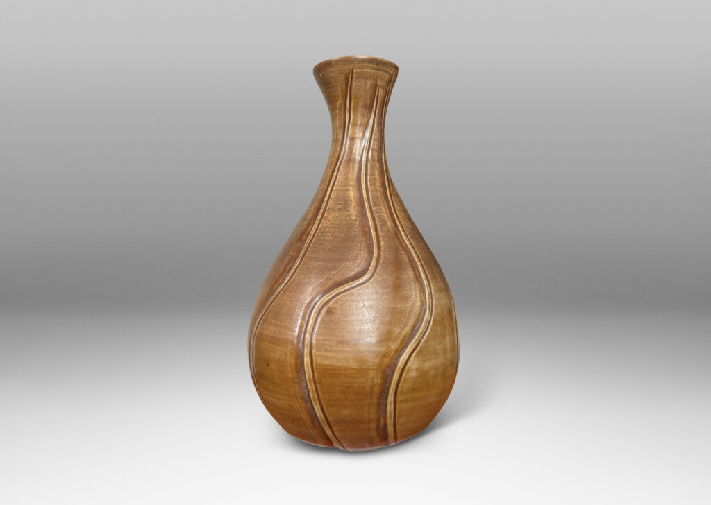 Gallery BAC drop form with flared mouth and vertical carved swirling lines, with a medium brown glaze