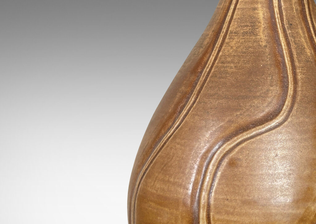 Gallery BAC drop form with flared mouth and vertical carved swirling lines, with a medium brown glaze