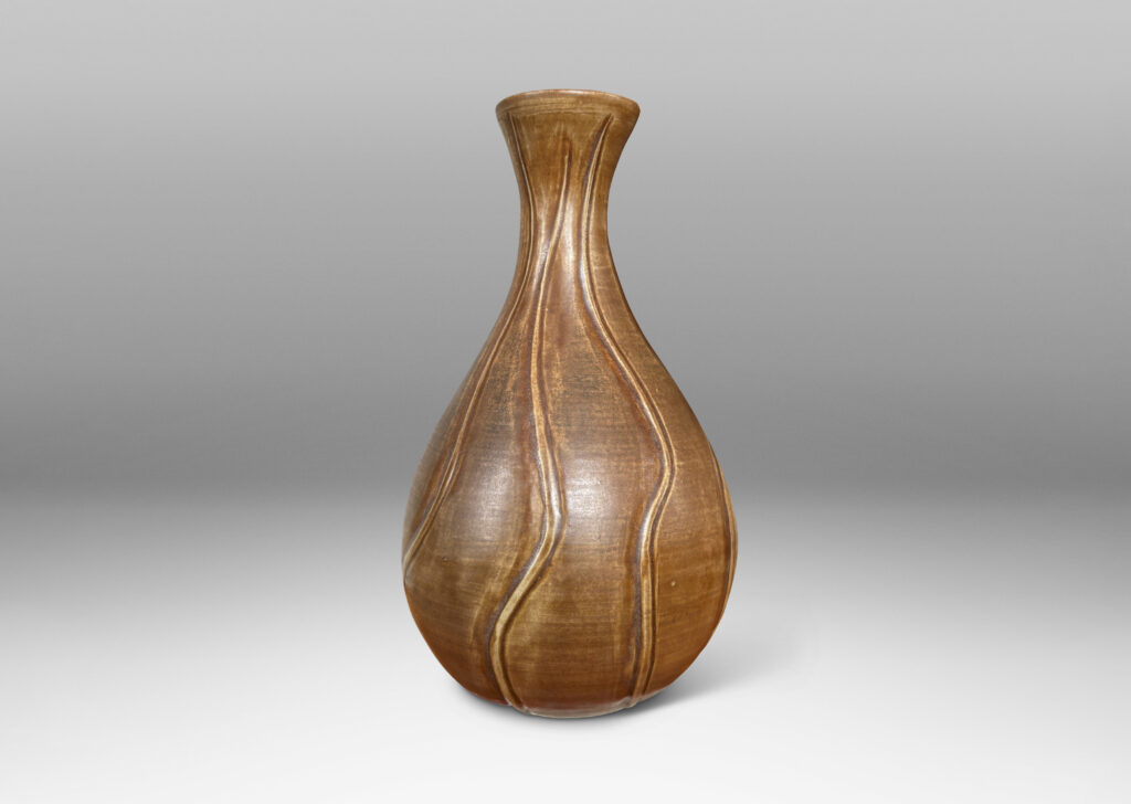 Gallery BAC drop form with flared mouth and vertical carved swirling lines, with a medium brown glaze