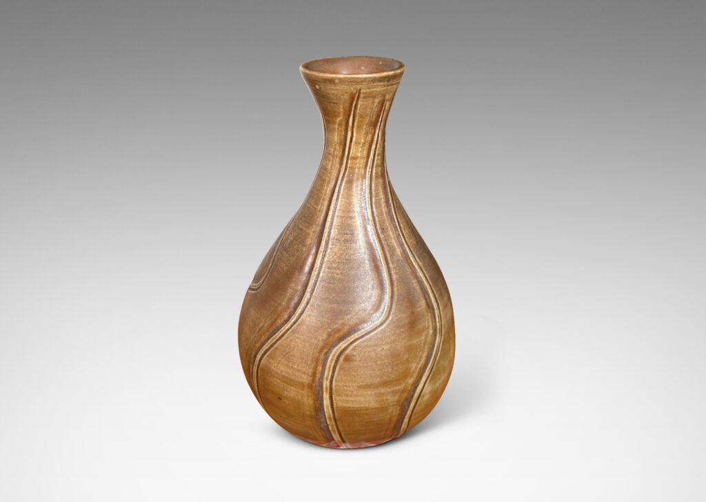 Gallery BAC drop form with flared mouth and vertical carved swirling lines, with a medium brown glaze