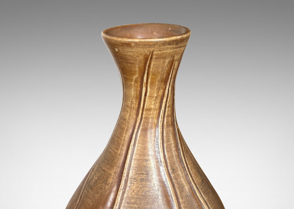 Gallery BAC drop form with flared mouth and vertical carved swirling lines, with a medium brown glaze