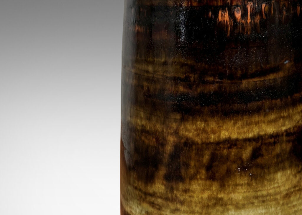 Gallery BAC tall bottle-like form glazed in brown tones with a striae texture
