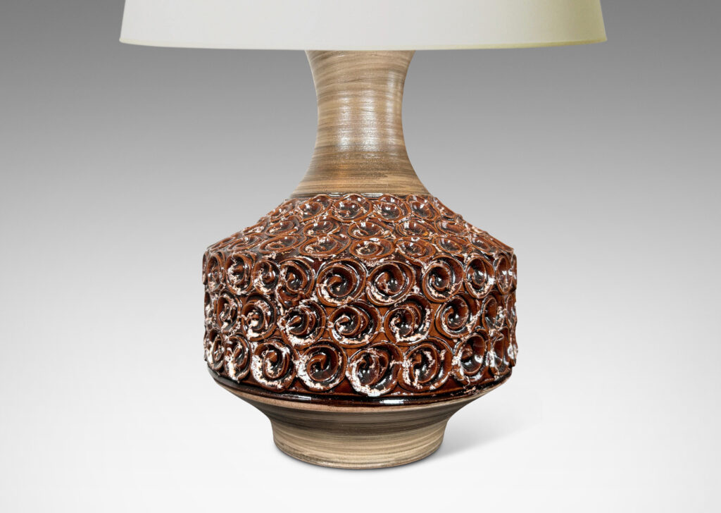 Gallery BAC floating drum form ornamented with swirl motifs glazed in a ganache brown, with sprouting neck and foot glazed in a striae gray-brown