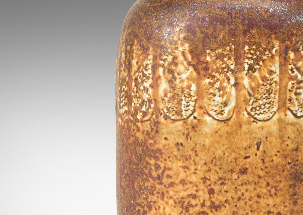 Gallery BAC bottle-like form with compressed cylindrical body and spouting neck, glazed in brown with band of ivory rectangles, all over-glazed with sponged dark brown
