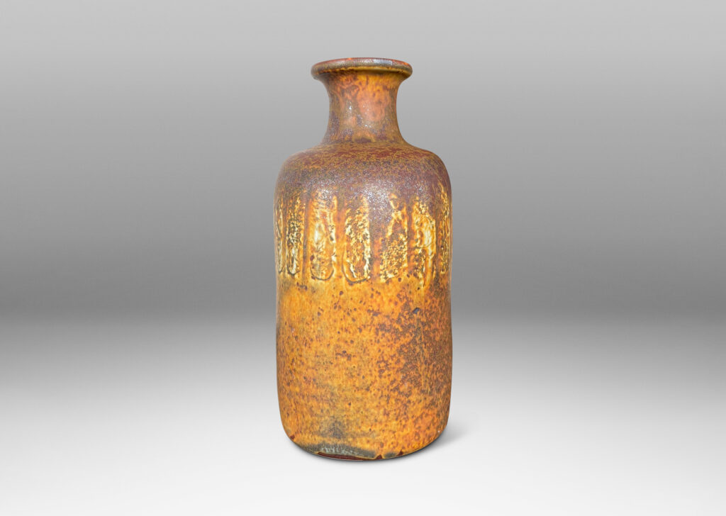 Gallery BAC bottle-like form with compressed cylindrical body and spouting neck, glazed in brown with band of ivory rectangles, all over-glazed with sponged dark brown