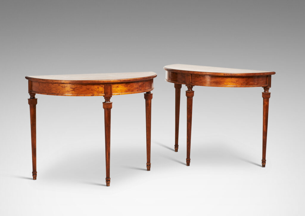 Gallery BAC semi-circular top with checkerboard marquetry and three round tapered legs with stylized tassel headers, which together form a circular table