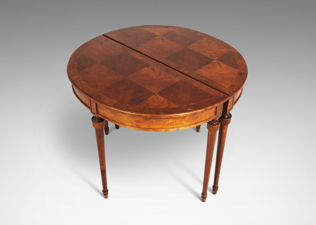 Gallery BAC semi-circular top with checkerboard marquetry and three round tapered legs with stylized tassel headers, which together form a circular table