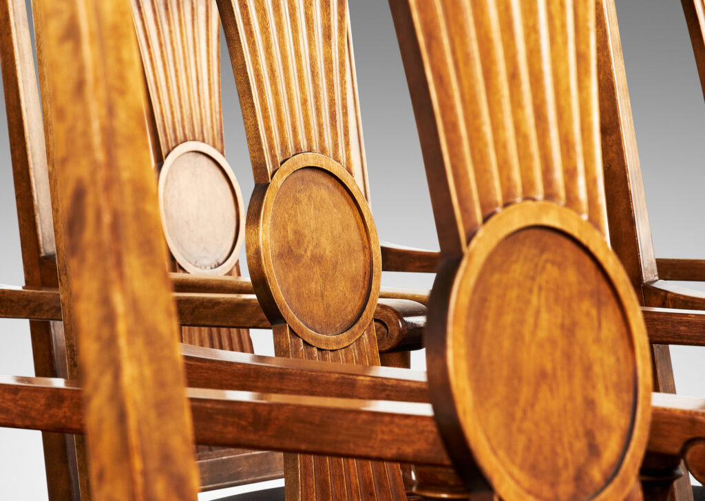 Gallery BAC squared backs with splats ornamented with radiating fluting and central disk medallions, arms with scrolled ends and turned supports, and tapered legs with stylized tassel headers