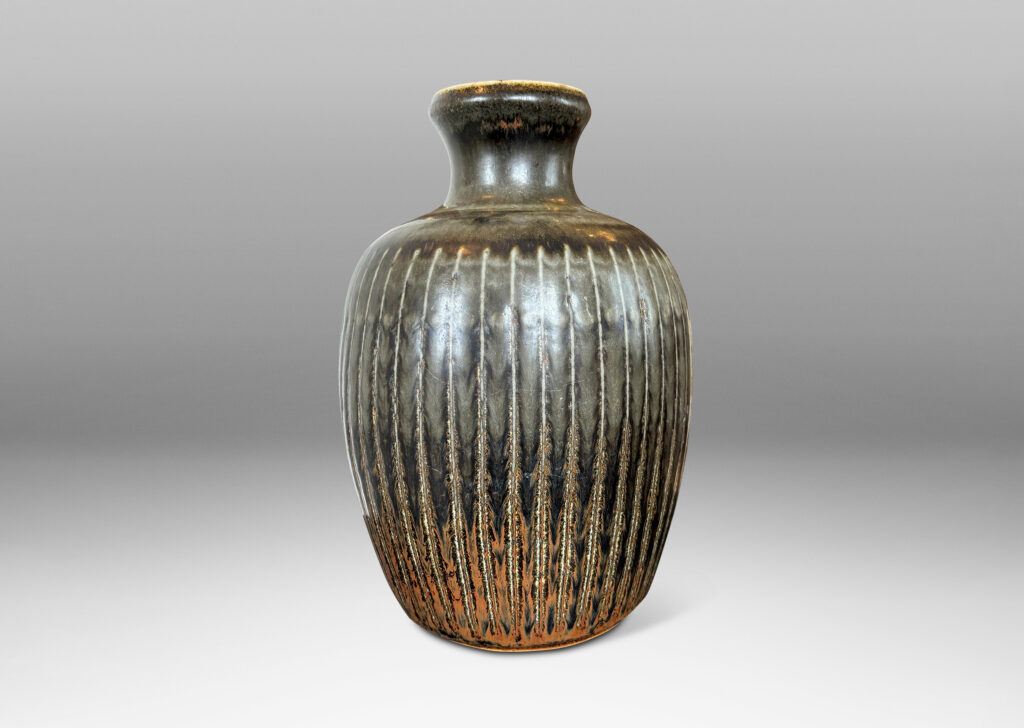 Gallery BAC ovoid form with coved neck and carved vertical pinstripes, glazed in black with red luster