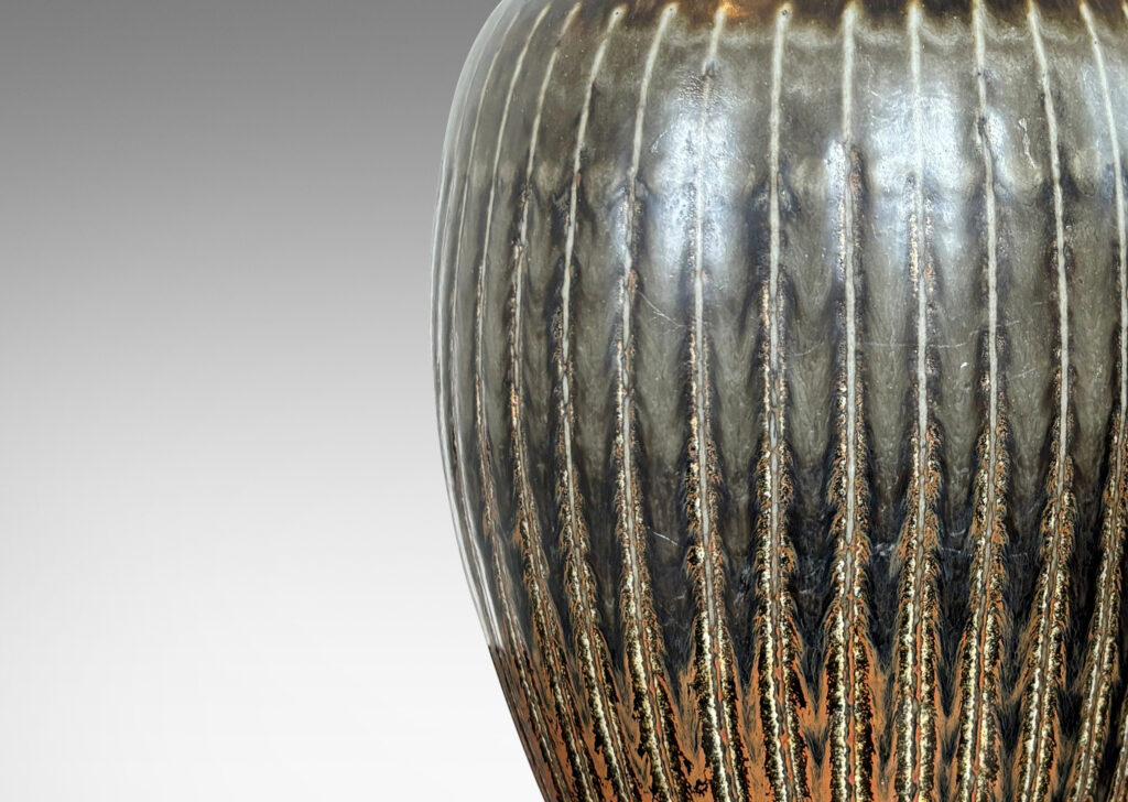 Gallery BAC ovoid form with coved neck and carved vertical pinstripes, glazed in black with red luster