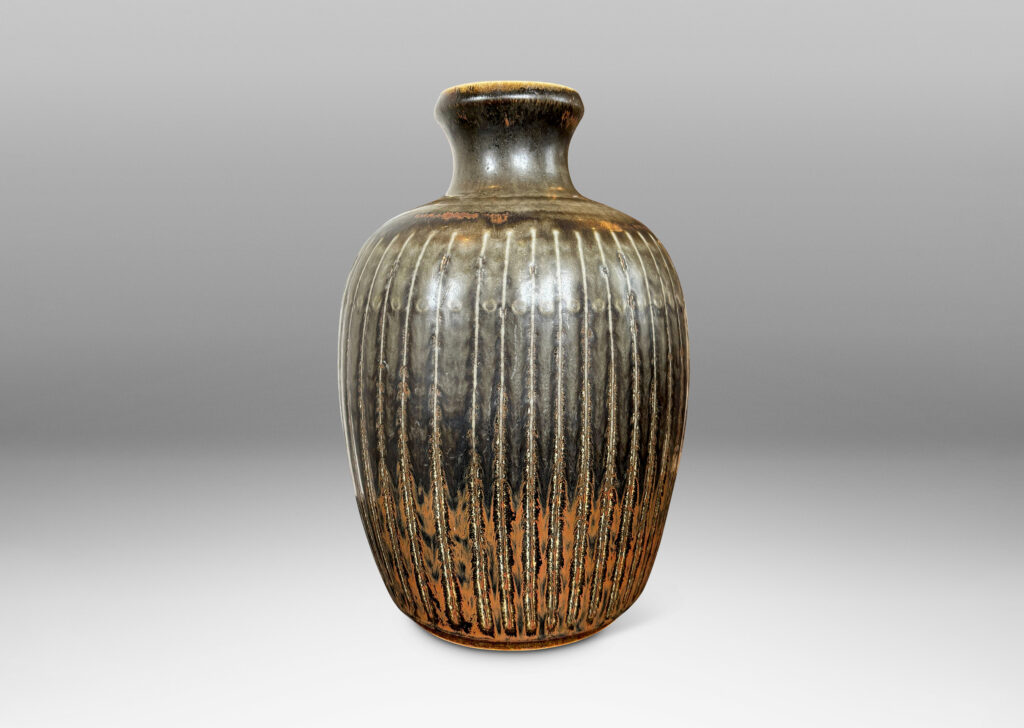 Gallery BAC ovoid form with coved neck and carved vertical pinstripes, glazed in black with red luster