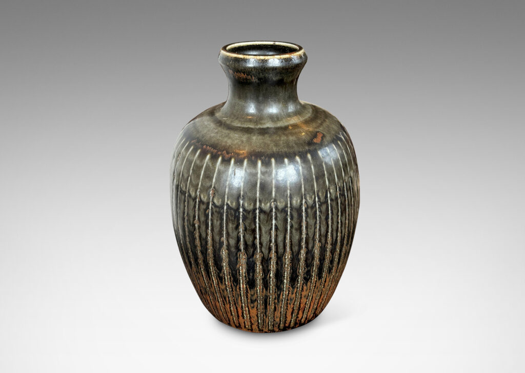 Gallery BAC ovoid form with coved neck and carved vertical pinstripes, glazed in black with red luster