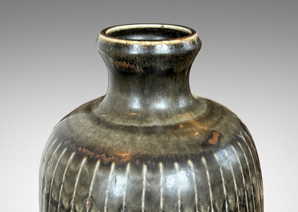 Gallery BAC ovoid form with coved neck and carved vertical pinstripes, glazed in black with red luster