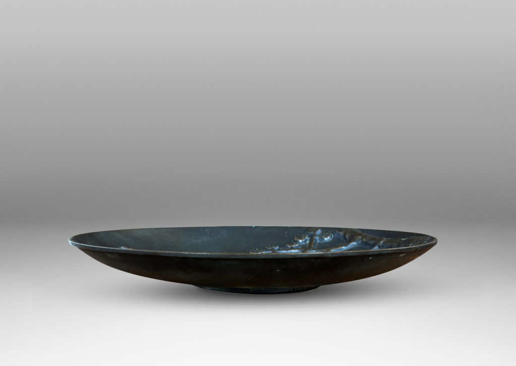 Gallery BAC gently modeled convex round form on a reveal, with relief dog, ducks and stylized landscape; patinated bronze
