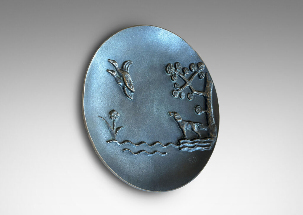 Gallery BAC gently modeled convex round form on a reveal, with relief dog, ducks and stylized landscape; patinated bronze