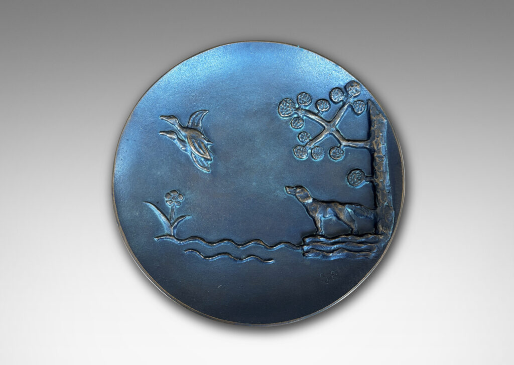 Gallery BAC gently modeled convex round form on a reveal, with relief dog, ducks and stylized landscape; patinated bronze