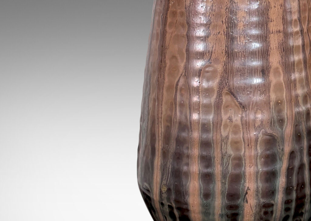 Gallery BAC ridged conical form on a disk plinth, glazed in flowing light, medium and dark browns
