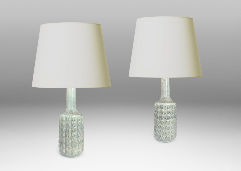 Gallery BAC bottle-like forms encircled in relief grids; glazed in pale gray with hints of ice blue and tan