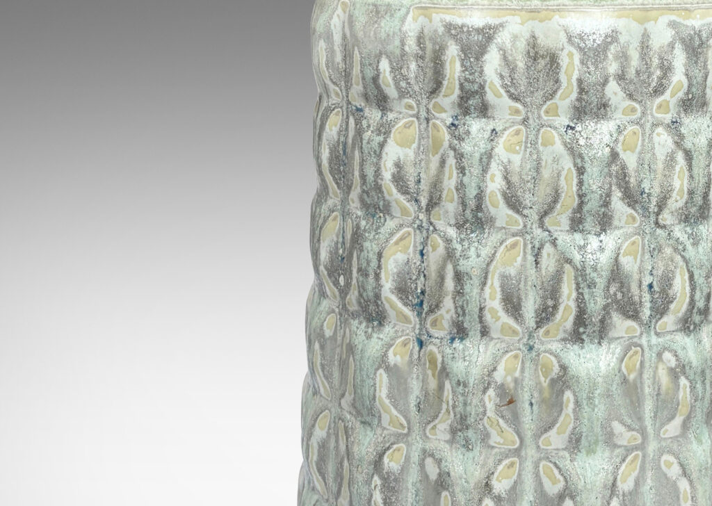 Gallery BAC bottle-like forms encircled in relief grids; glazed in pale gray with hints of ice blue and tan