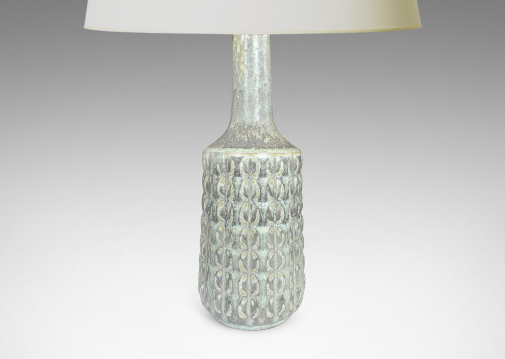 Gallery BAC bottle-like forms encircled in relief grids; glazed in pale gray with hints of ice blue and tan