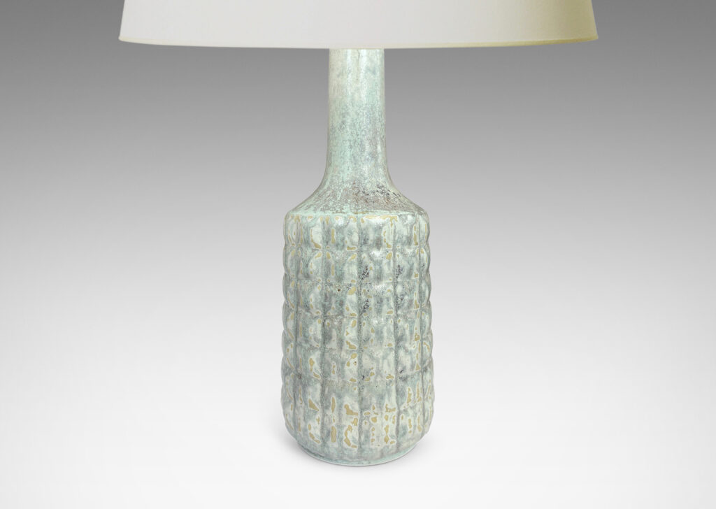 Gallery BAC bottle-like forms encircled in relief grids; glazed in pale gray with hints of ice blue and tan