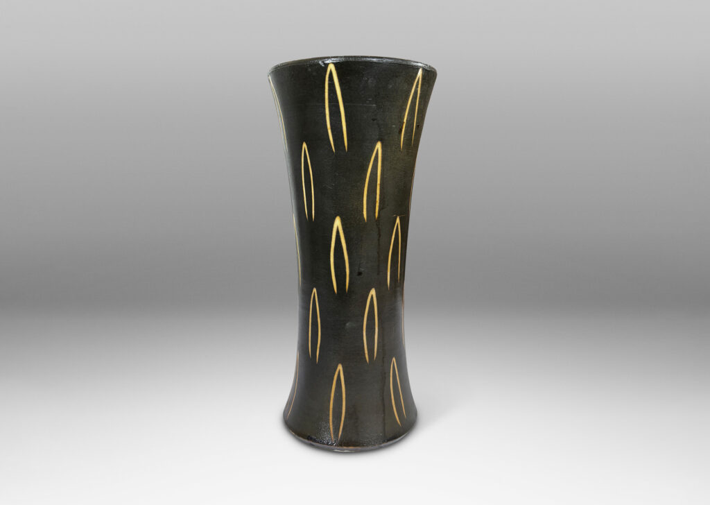 Gallery BAC gently trumpeting form glazed dark brown, with sgraffito leaf motifs