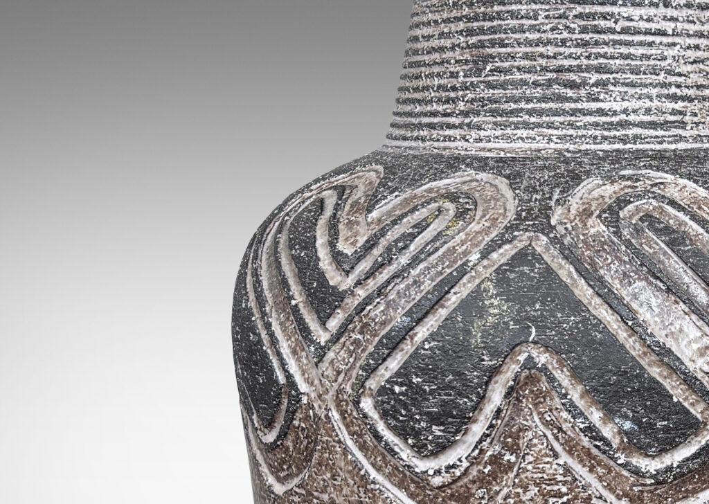 Gallery BAC tapered drum form with carved band of alternating heart motifs, and tall ridged conical neck, glazed in matte dark and light browns