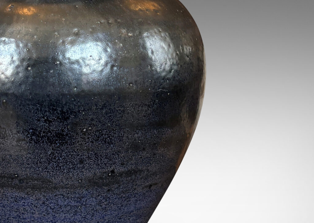 Gallery BAC tapered form with flared mouth, glazed in black with hints of purple with an orange peel texture